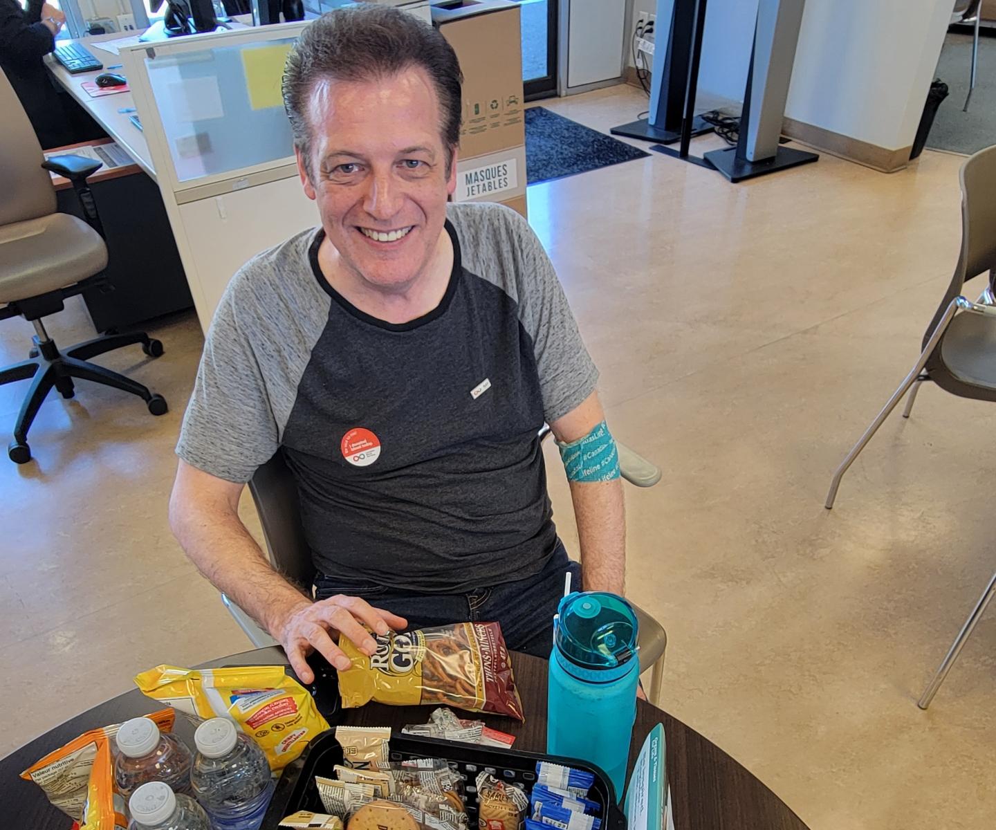 Blood donor in donor centre with snacks and water bottle