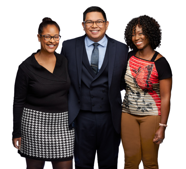 A group of three people standing together smiling at the camera