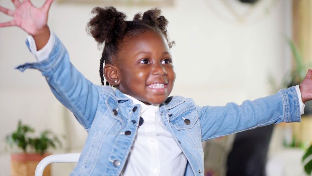 Preschool age girl smiling with arms outstretched
