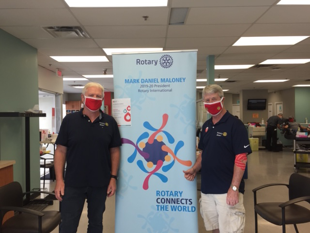 Image of Tom Roth and Peter Schultz standing in front Rotary popup banner stand.