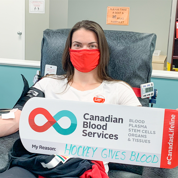 Image of blood donor Blayre Turnball sitting in the chair donating blood at a donor centre.