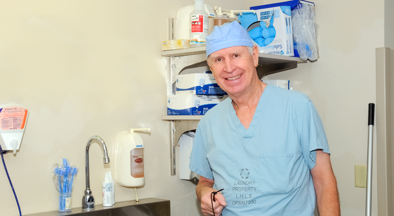 Image of William Wall standing next beside the sink holding his glasses