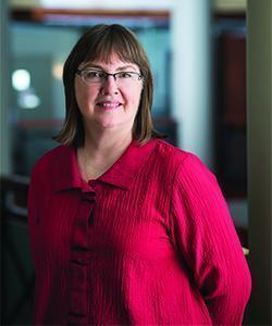 Dr. Dana Devine Chief Scientist with a red shirt and brown hair