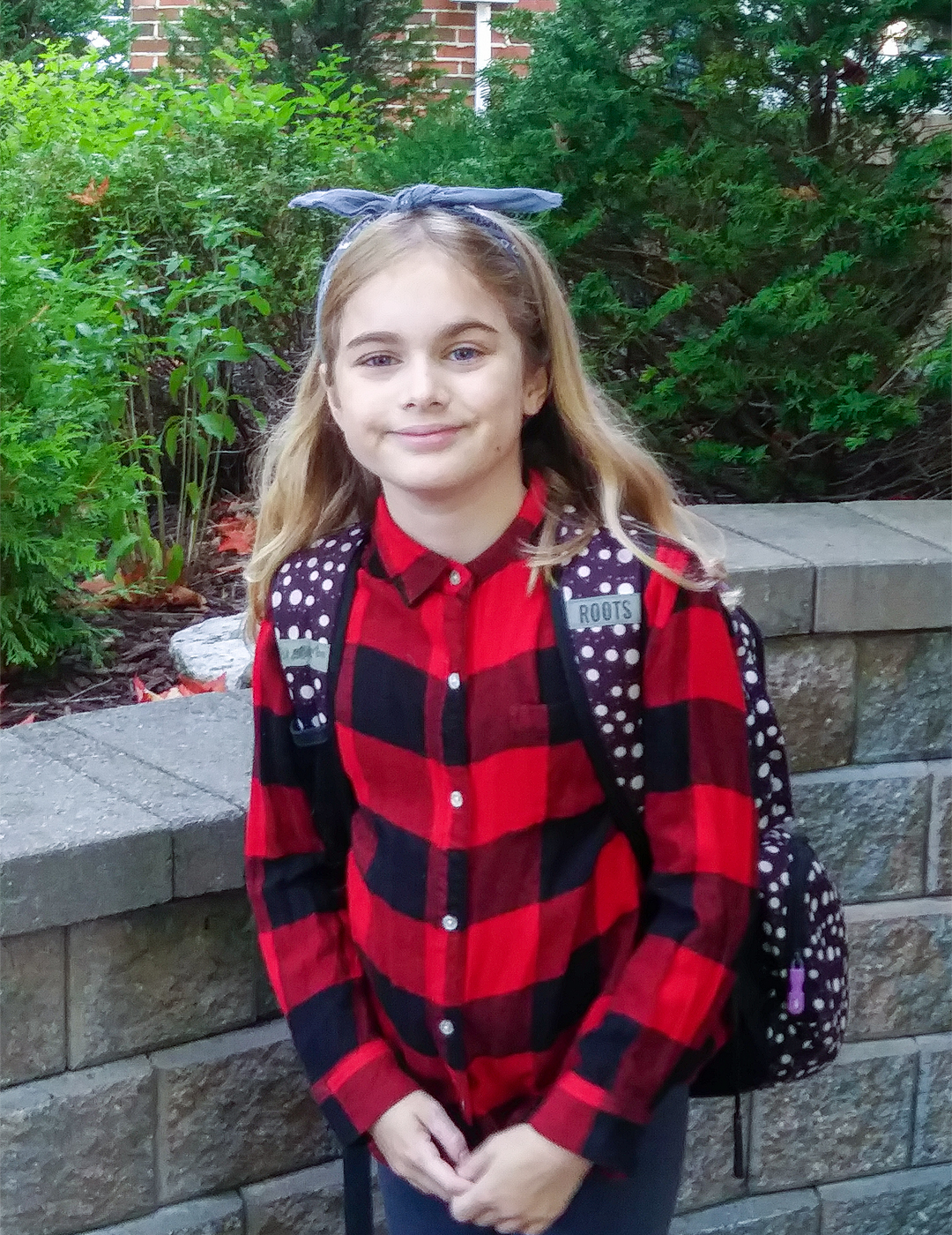 Image of Elsa Norton as a grade 6 standing in front of a stone ramp at an amusement park