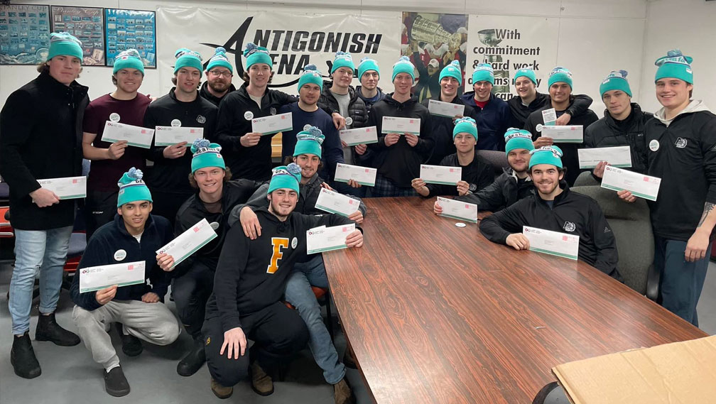 Young hockey players huddled together holding buccal swab kits for joining the stem cell registry.