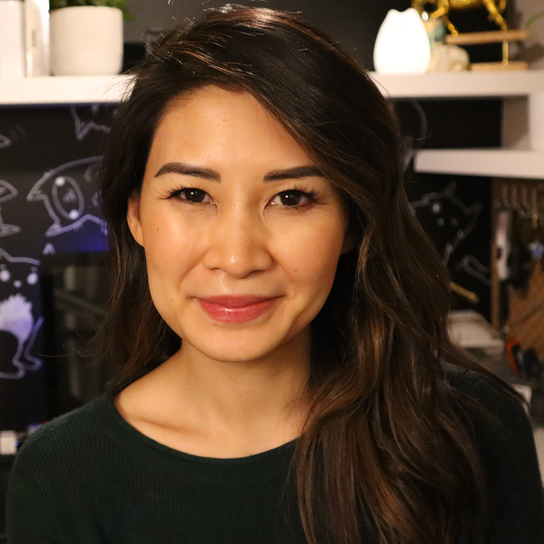 Photo of Susan Nguyen standing in front a desk in a bedroom with shelves