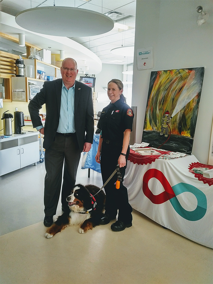 Image of Annette Thompson and director of donor relations for the Atlantic Canada Peter MacDonald with a therapy dog