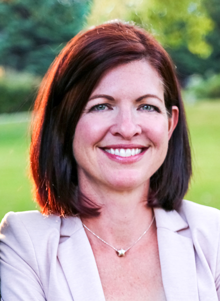 Headshot image of Dr. Meagan Mahoney standing beside a tree