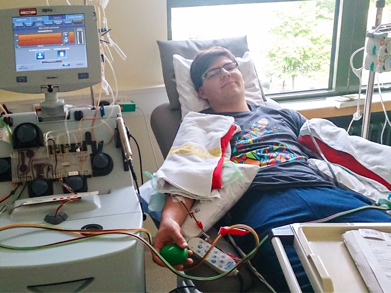 Image of Manuel Gamperl lying in the hospital hooked up to machine to donate stem cells.