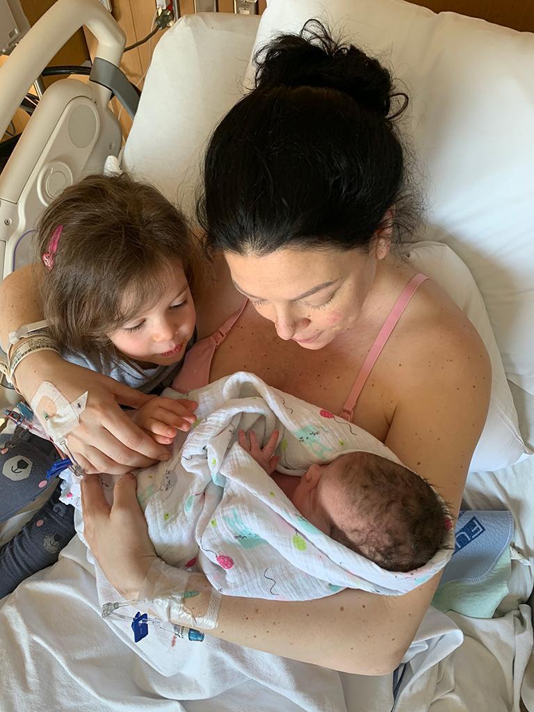 Image of Meghan with her daughter holding her new baby
