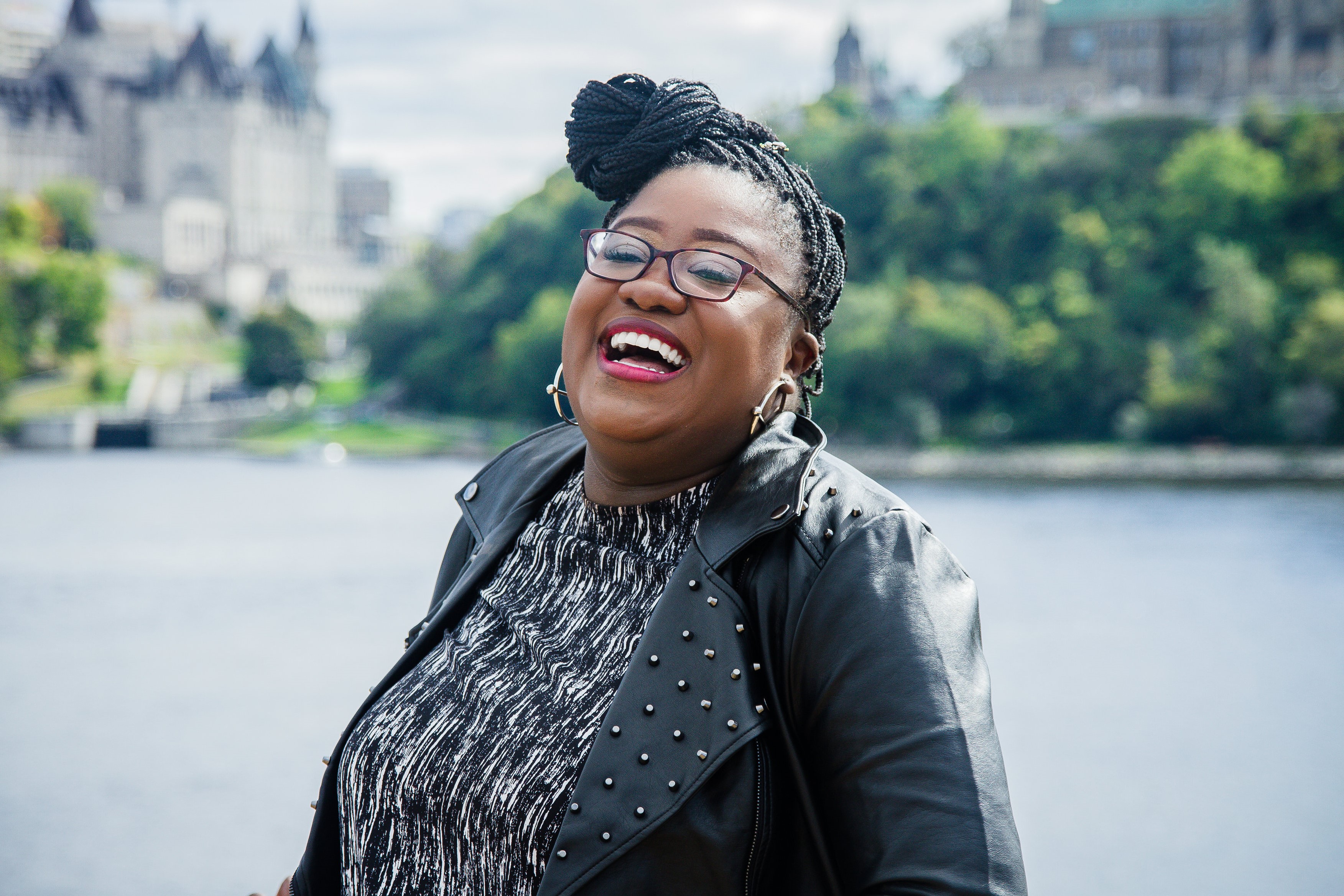 Nahomie Acelin, who wrote The Battle of Ottogatz to help raise awareness of sickle cell disease, smiles outside on a summer day near the Ottawa River.