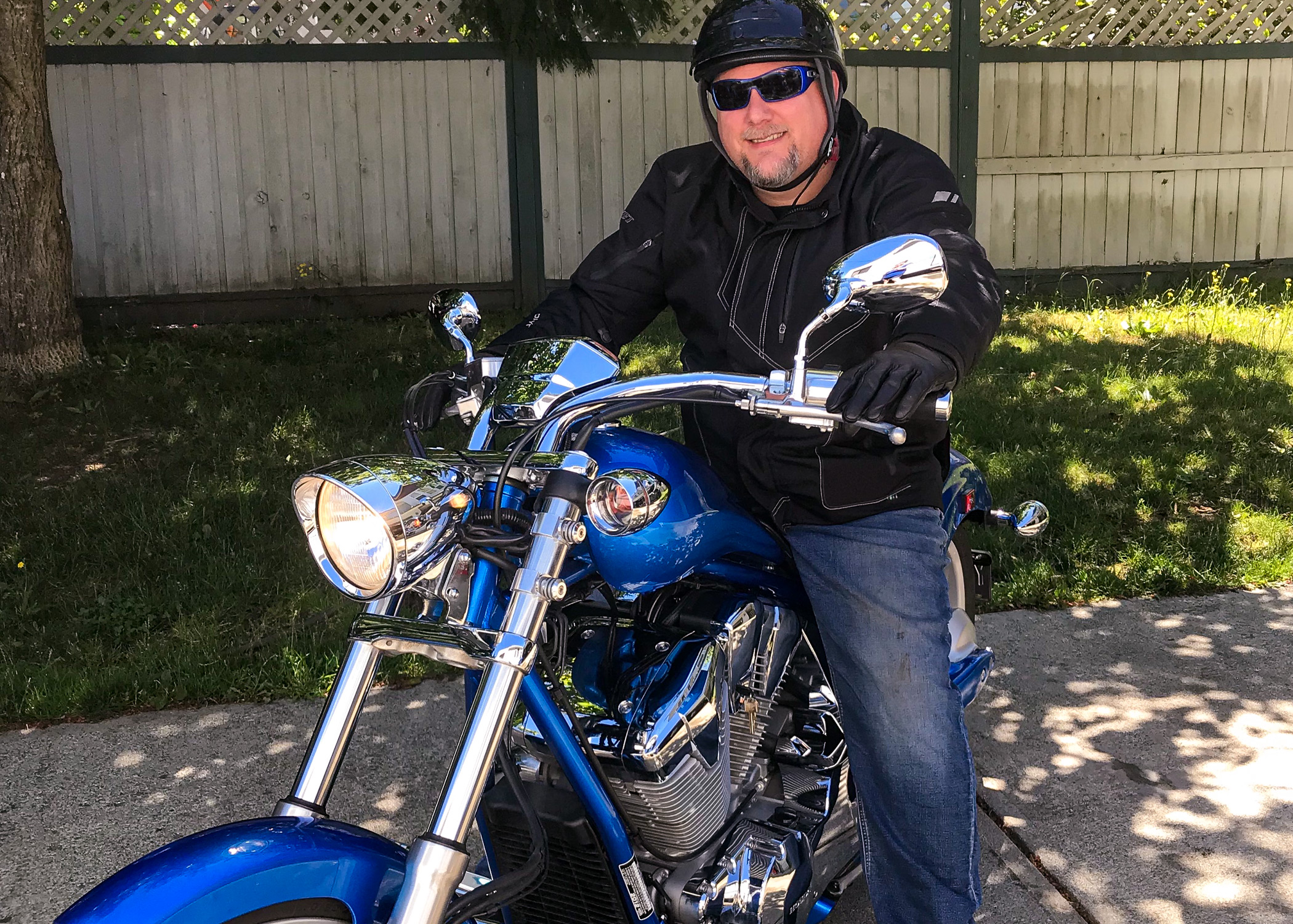 Image of blood recipient Nathan Olson posing on his motorcycle wearing full motorcycle gear.
