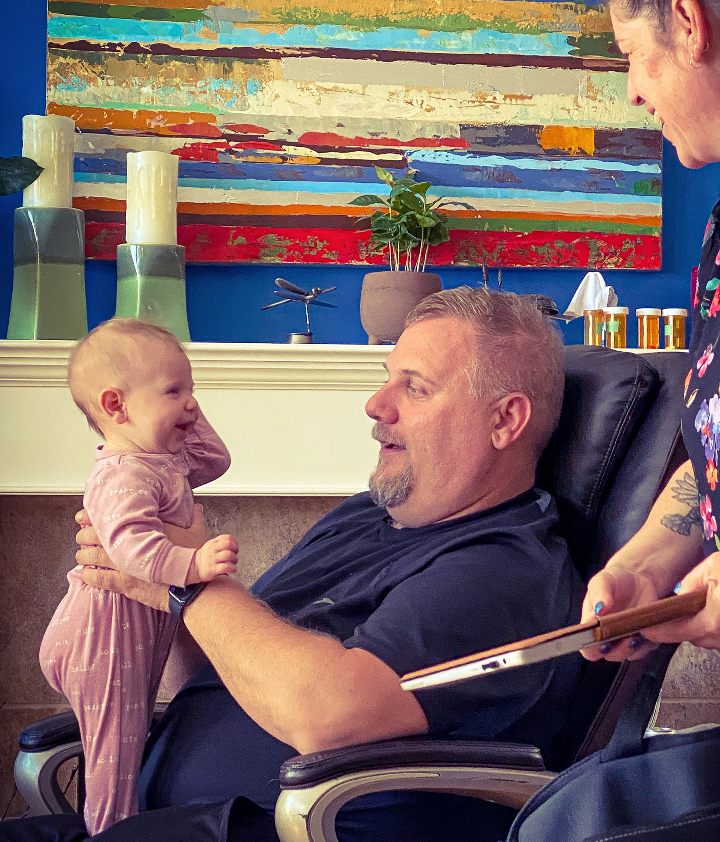 Image of blood recipient Nathan Olson sitting down holding his granddaughter, Emersyn Olson