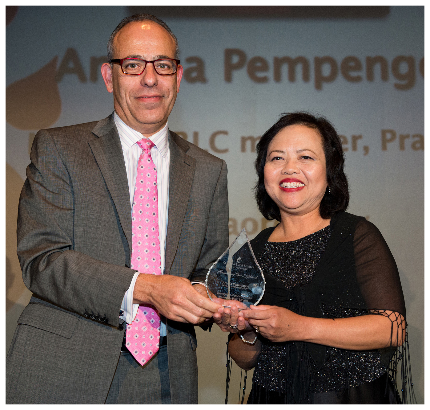 Dr. Graham Sher (left) honours longtime volunteer, the late Amalia Pempengco (right) with a Schilly Award