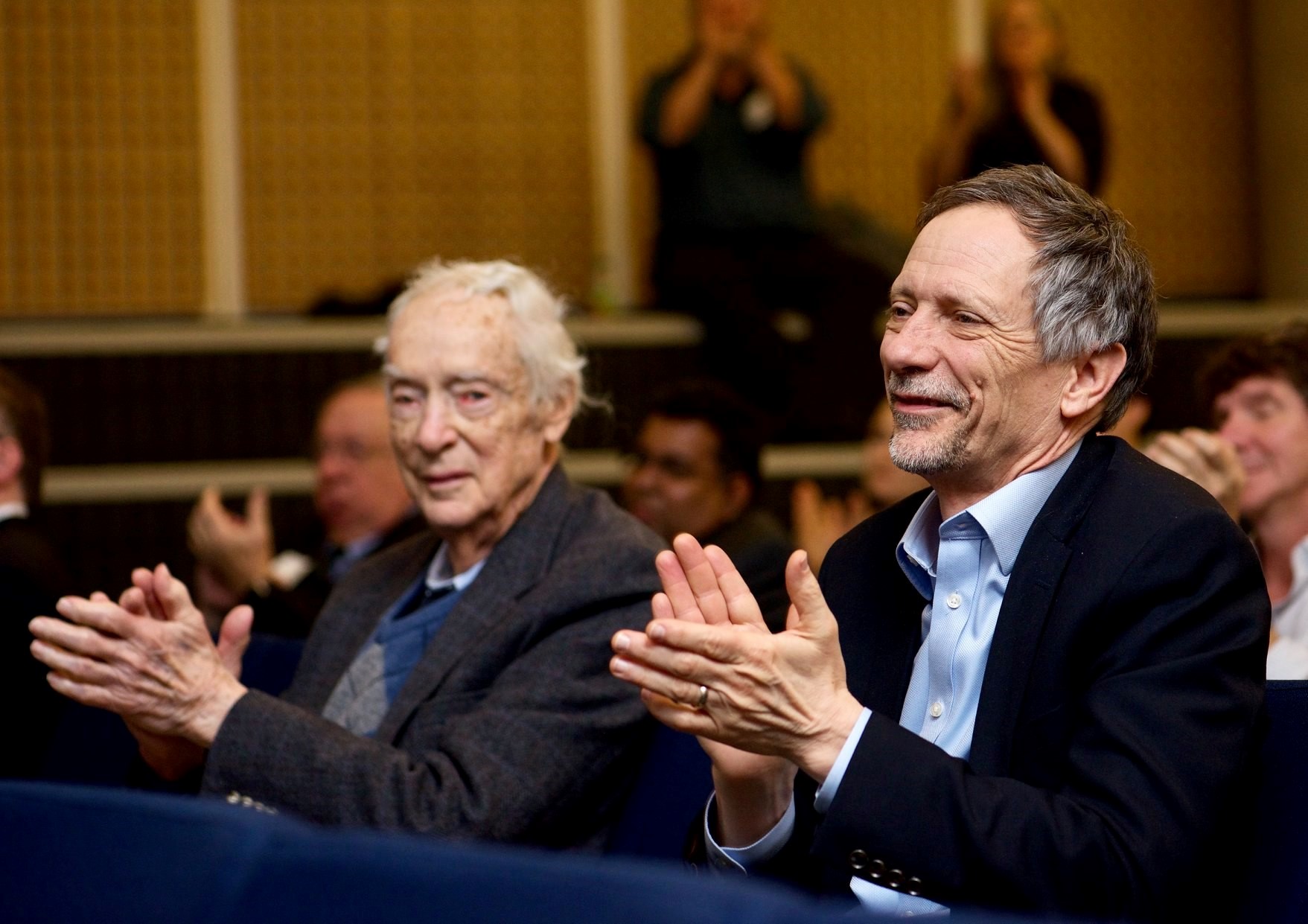 Dr. Earl W. Davie (left) enjoying presentations at the 13th annual Earl W. Davie Symposium in Vancouver. (Photo courtesy of the Centre for Blood Research.)