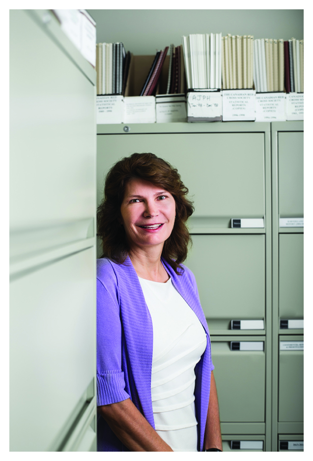 Image of associate director of epidemiology and surveillance Dr. Sheila O’Brien standing in front of filing cabinets