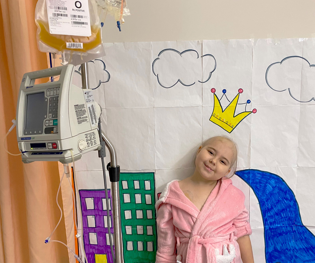 Abigale smiling next to bag of platelets