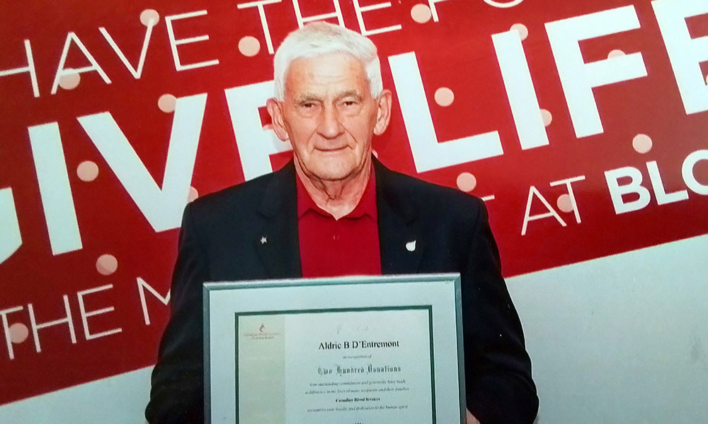 Aldric d'Entremont holding a framed certificate