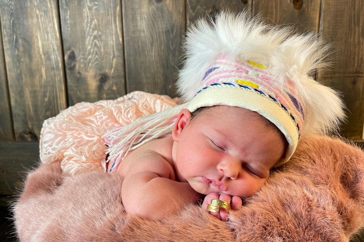 Cord blood donor Flora-Lyn Russ sleeps on a fur blanket that’s placed on a wooden bench.
