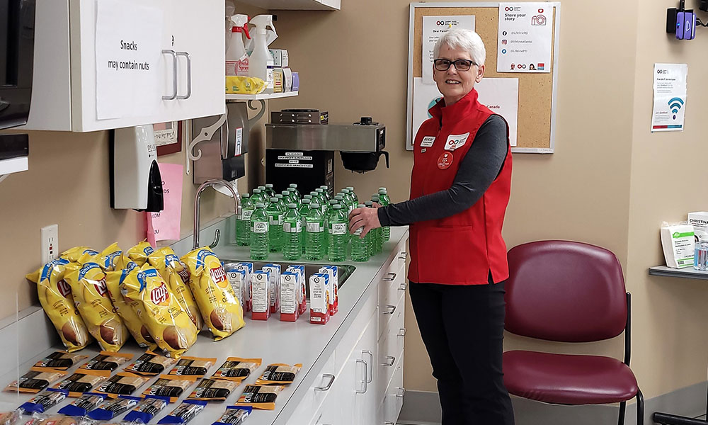 woman in red vest standing in front of snack counter