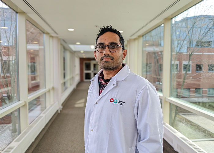 Dr Harinad Maganti standing in a overpass with a lab coat