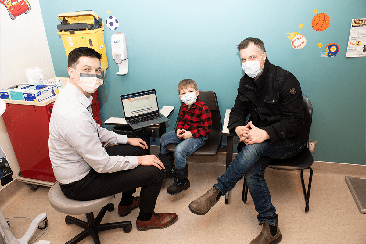 Child with hemophilia and his dad speak with pharmacist at CHEO clinic