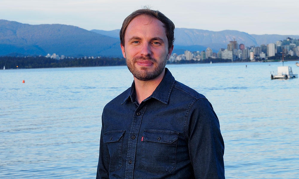 Person standing in front of the water wearing a blue shirt