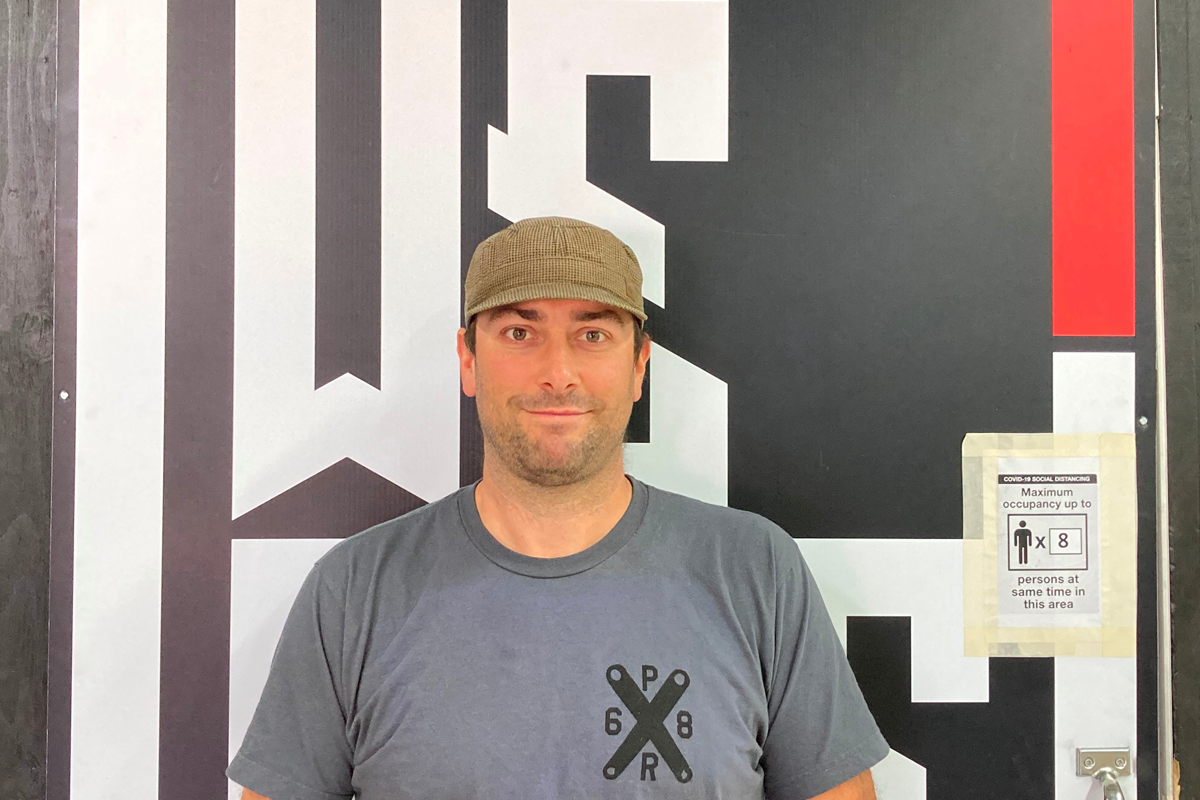 Production manager Dustin Windross in front of a We Are One Composites sign