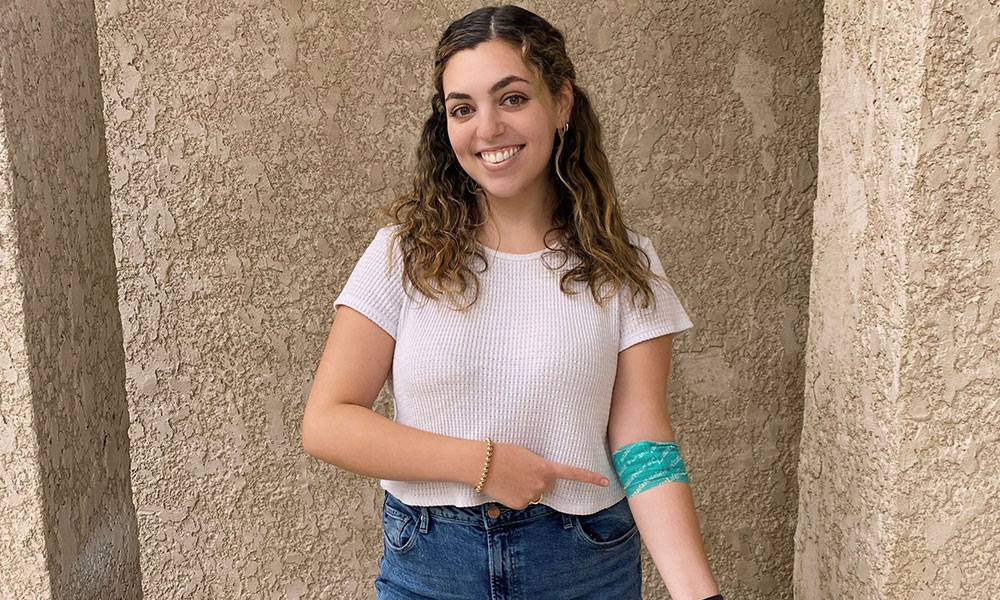 young female standing in front of a wall