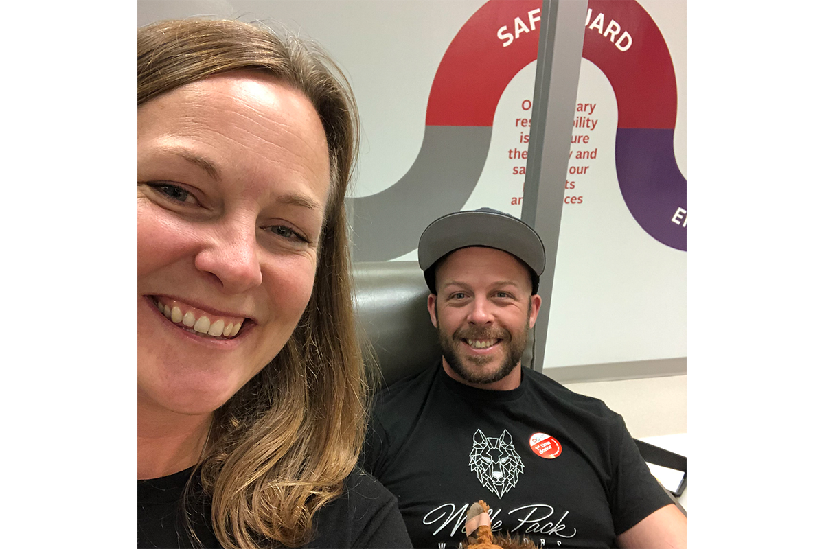 Kristy and Harrison Wolfe smiling at donor centre wearing Wolfe Pack T shirts