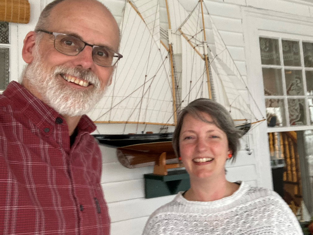 A blood recipient and blood donor in front of a model ship
