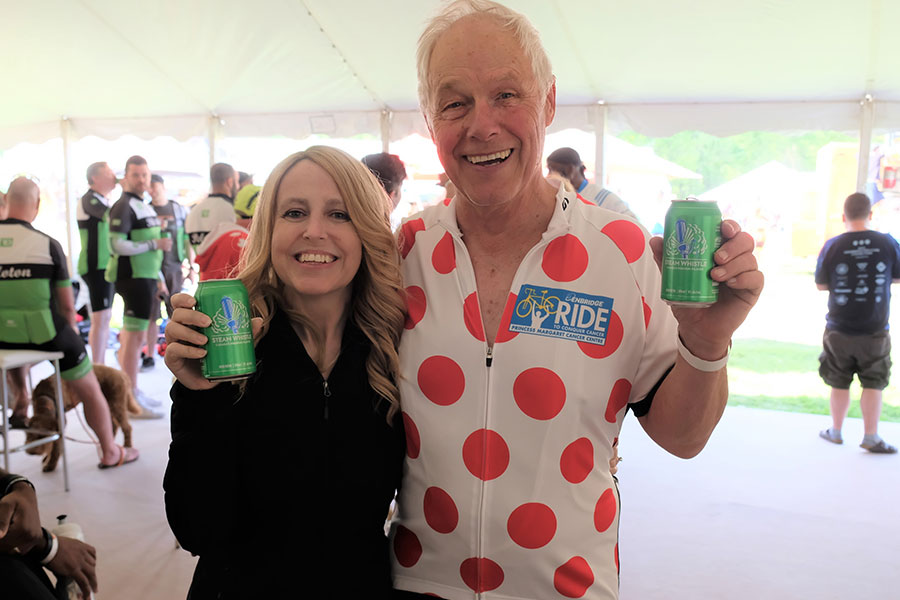 Father and adult daughter celebrating with beer after cycling fundraiser