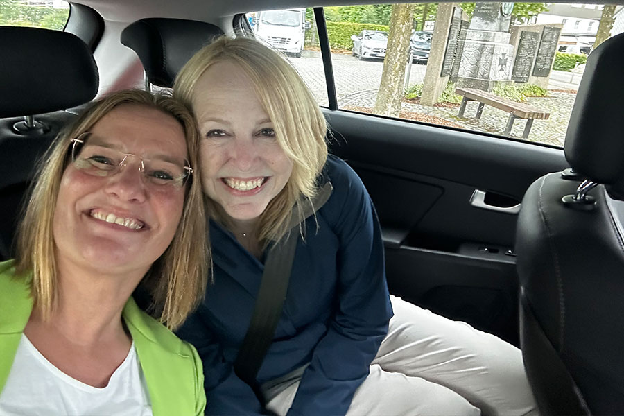 Stem cell donor and stem cell recipient smiling with heads together in the backseat of a car