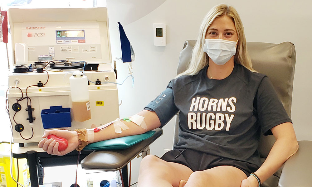 Woman wearing “Horns Rugby” T-shirt donating plasma