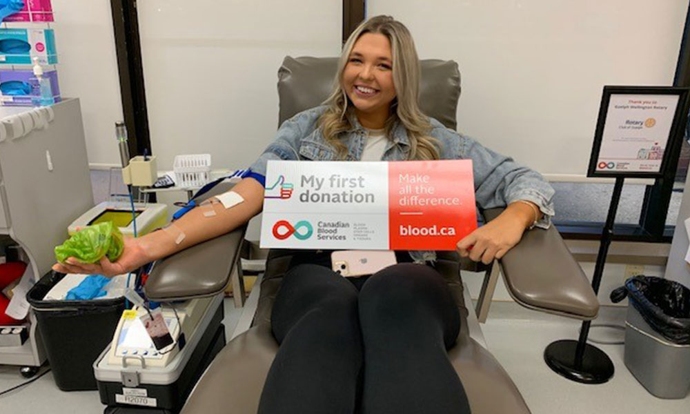 first time blood donor with sign that says “my first donation”