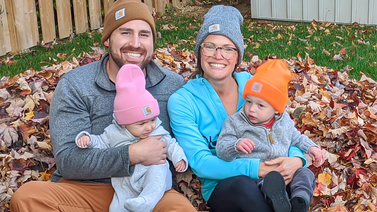 Image of blood donor and registered organ donor Greg Kitchen and wife Deanna Kitchen holding their children Cole and Michaela in their backyard sitting in a pile of leaves.