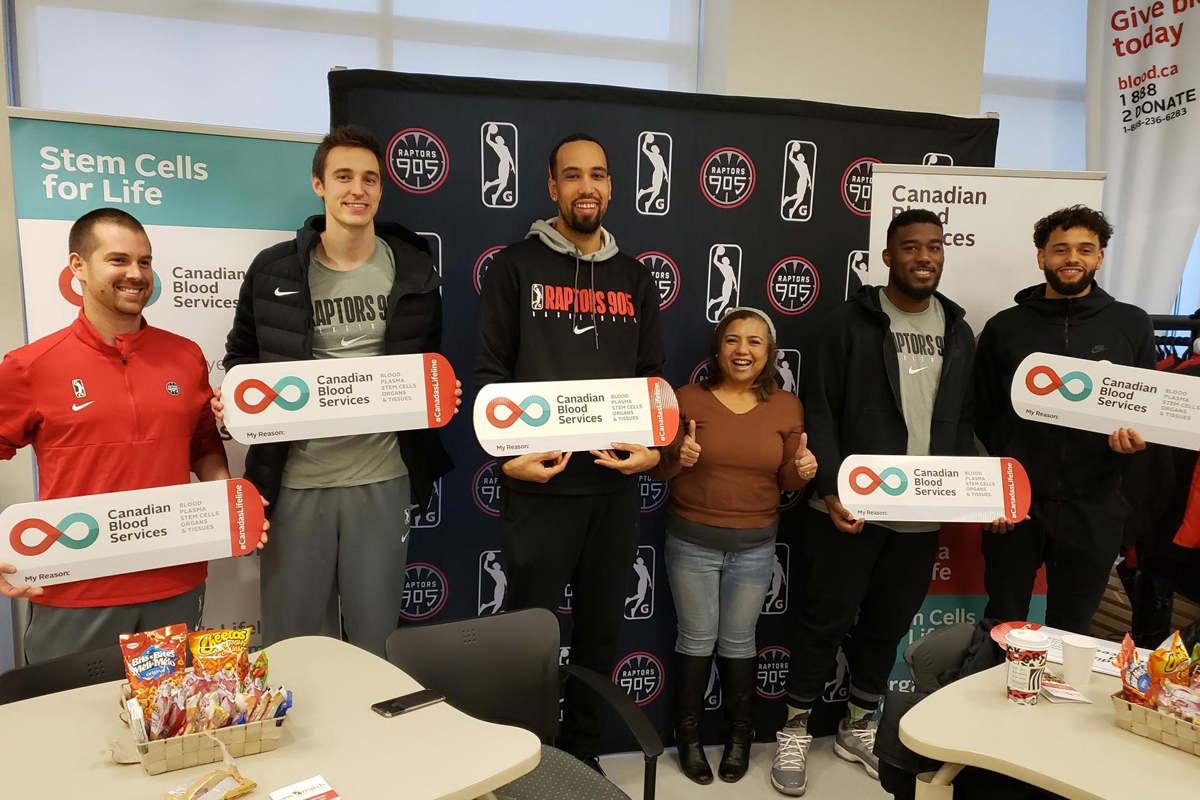 Lilet Raffiñan, who recruits blood donors for Canadian Blood Services, stands with members of the Raptors 905 team during their group blood donation event in Mississauga.