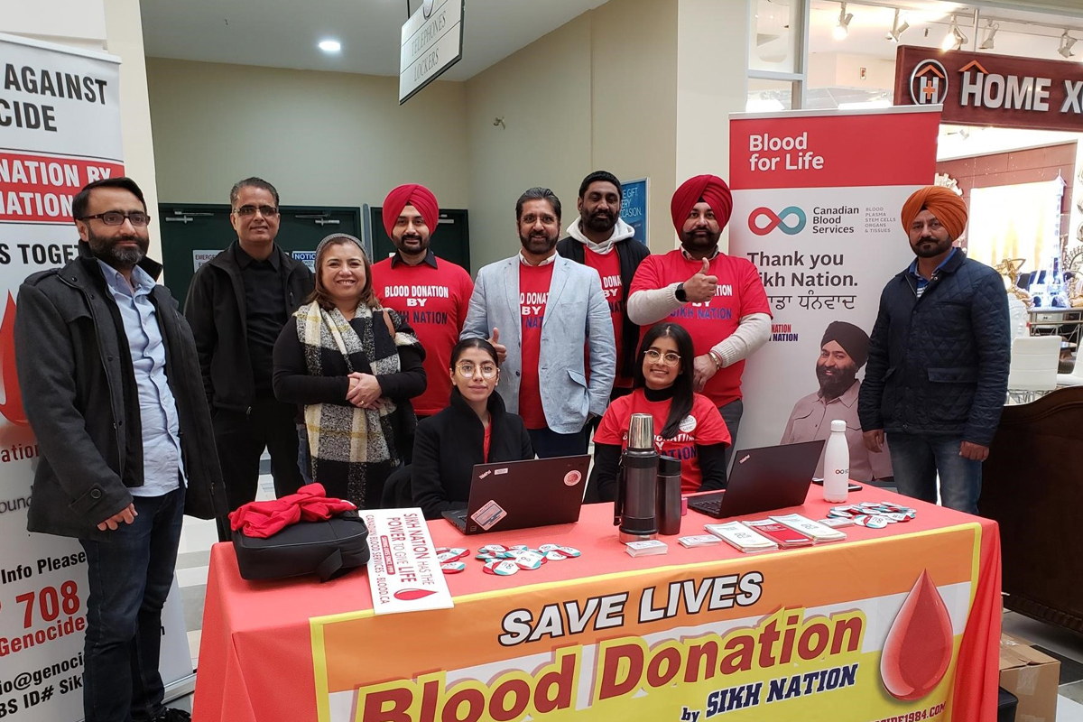 Lilet Raffiñan, who recruits donors for Canadian Blood Services, stands with members of Sikh Nation during their group blood donation event in Brampton.