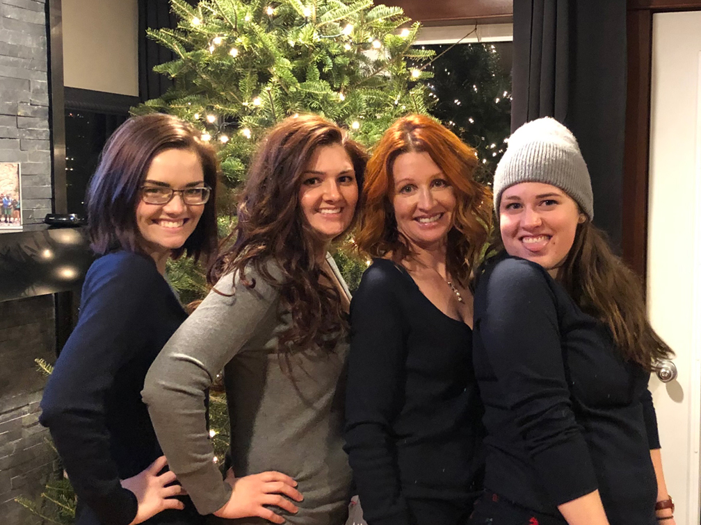 Lizzy Burns poses in front of a Christmas tree with her sisters Jessica Martin and Hannah Burns and their mother Kim Burns.
