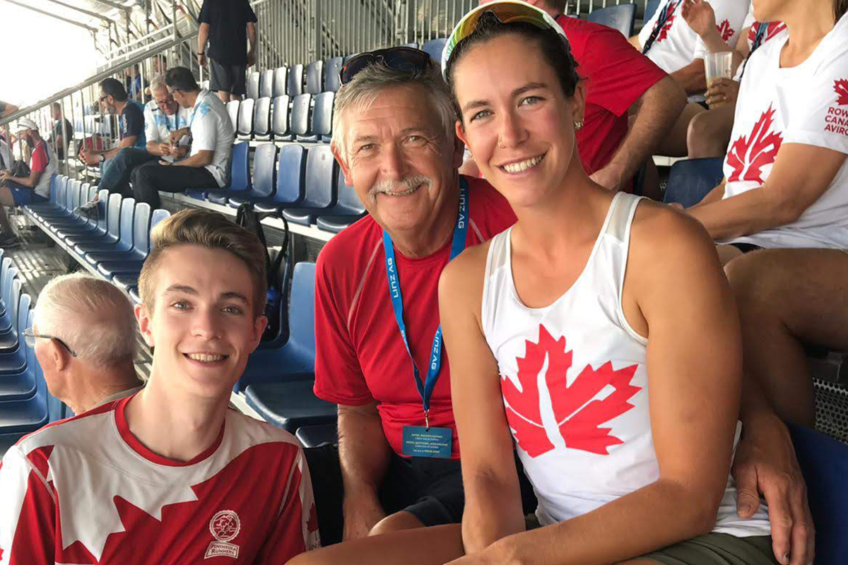 A father with his son and daughter sitting in the stands at an event