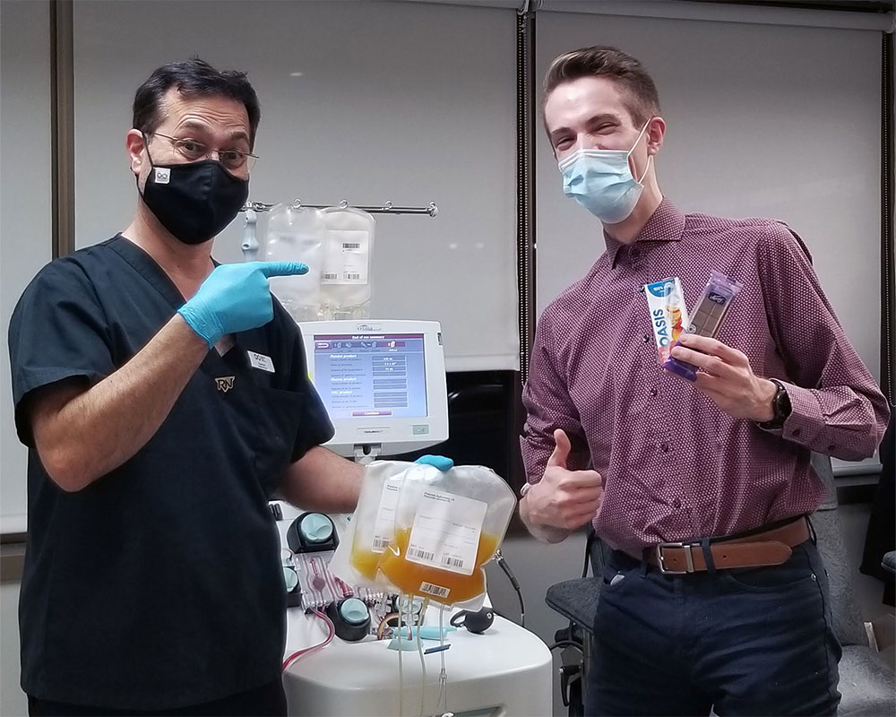 Platelet donor and donor centre employee holding platelet bags and snacks