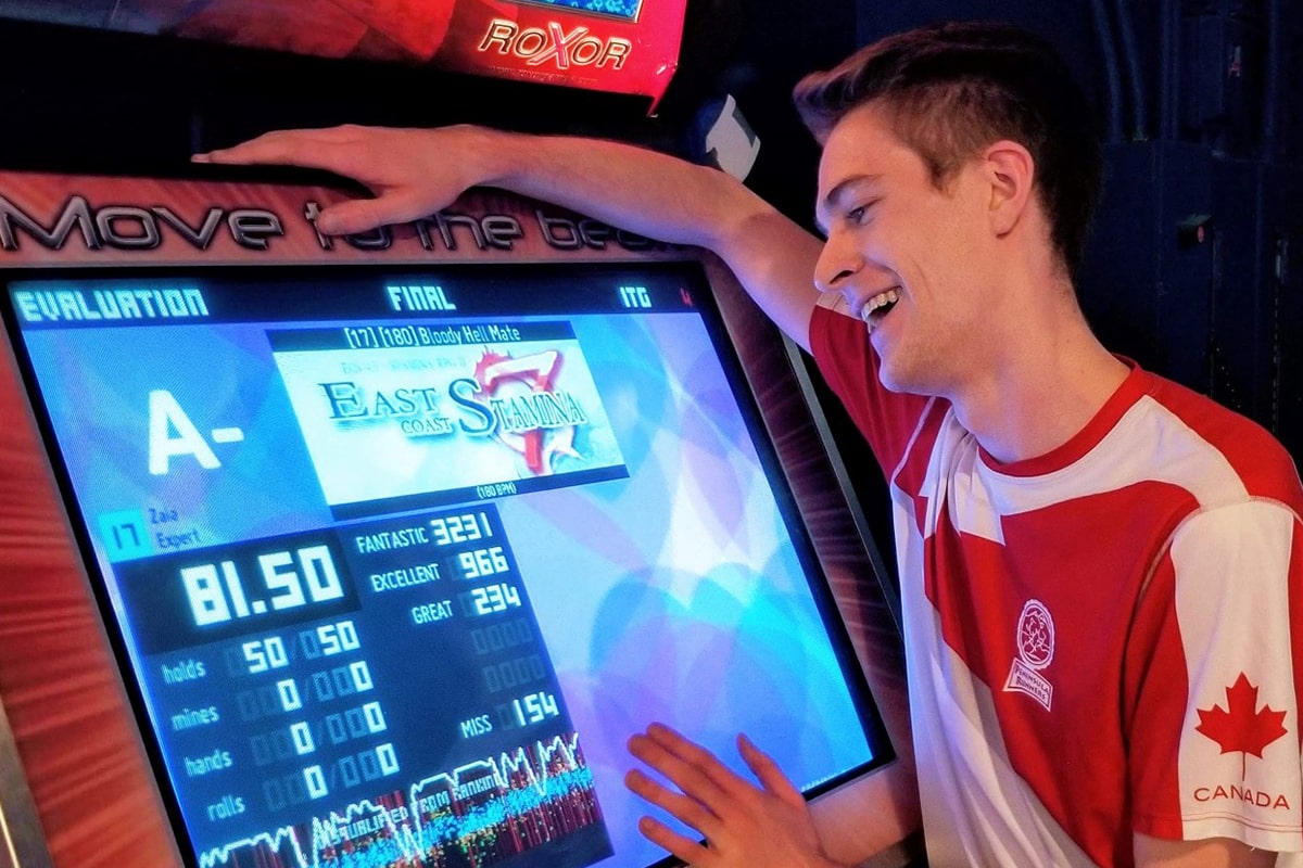 Video game enthusiast with hands on the screen for arcade game In the Groove