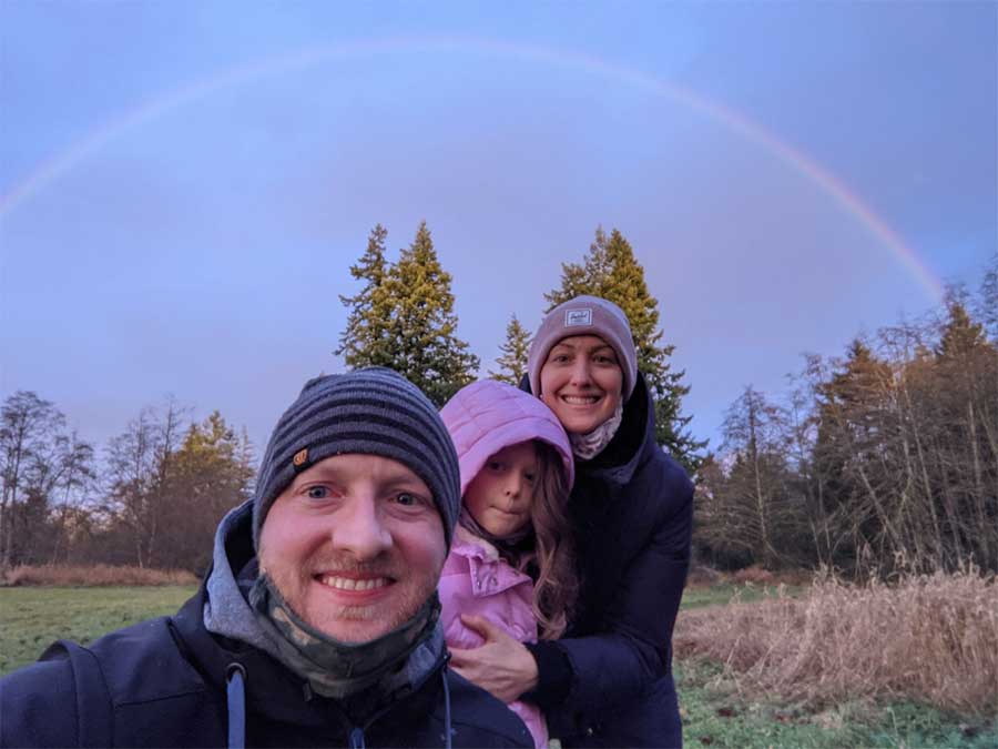 Blood and stem cell recipient, Miranda Webber, with her daughter and husband outdoors with rainbow in the background