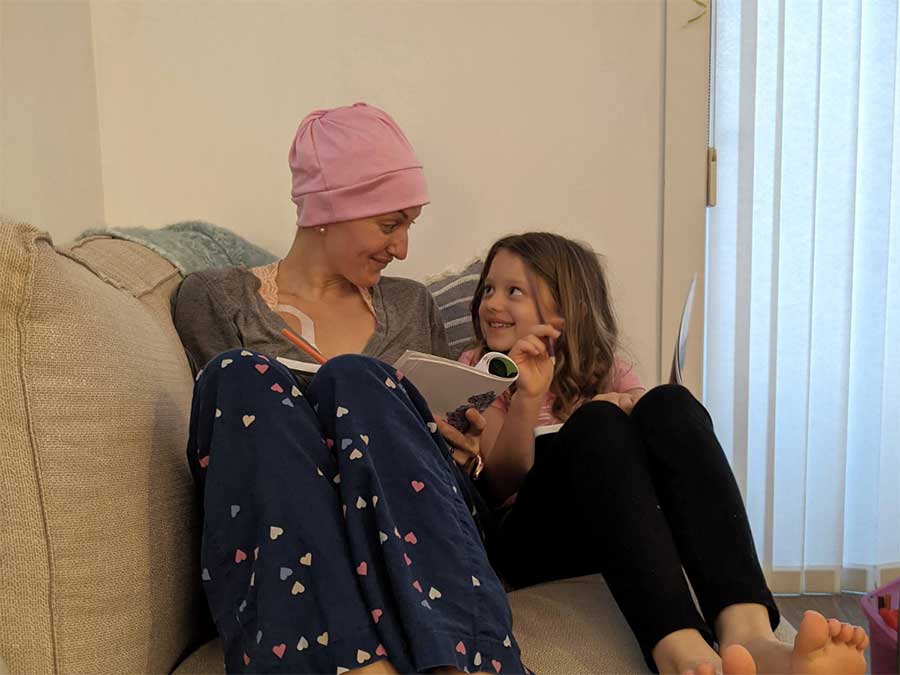 Blood recipient and fundraiser, Miranda Webber, sitting and colouring with her daughter
