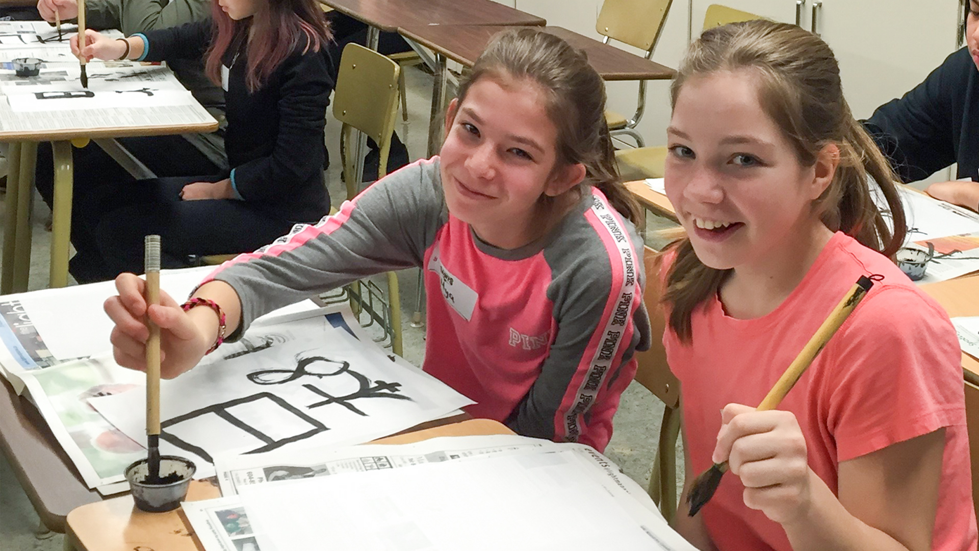 Image of two young girls in a classroom, Mya and Cassie