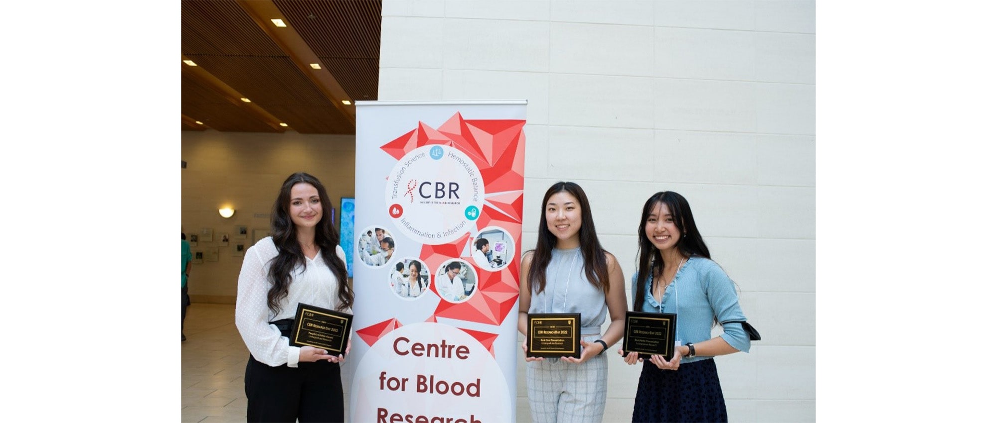 Summer students who won awards holding their award plaques.