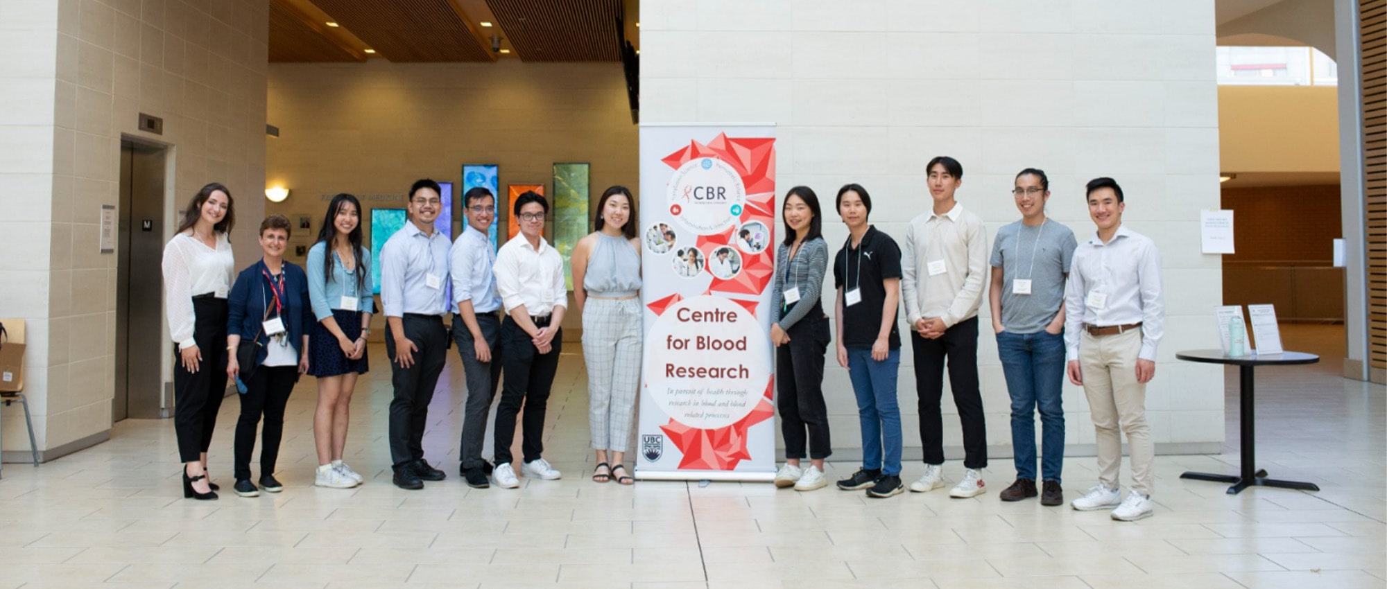 Summer students holding their posters in the Life Sciences Centre West Atrium
