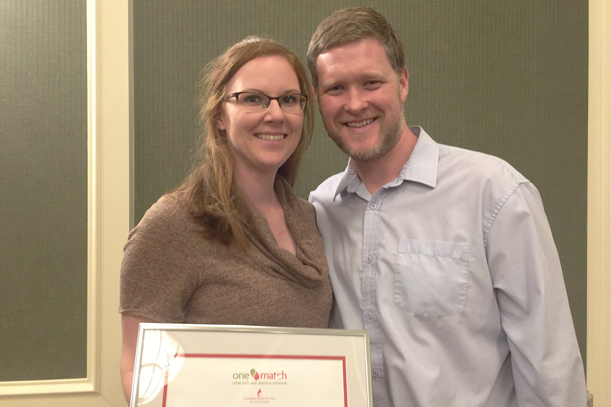 Rachel Van Pelt and husband Michael Van Pelt pose with a plaque that was presented to Rachel by Canadian Blood Services Stem Cell Registry.