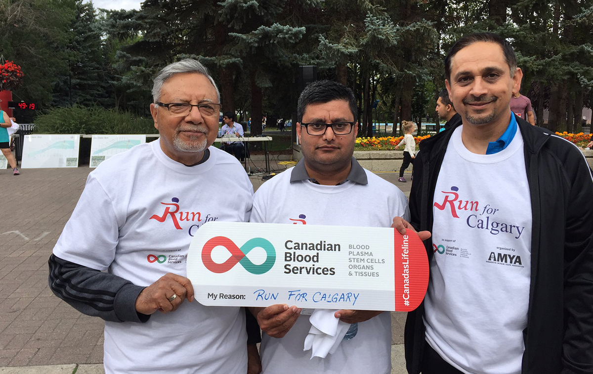 Run for Calgary volunteers holding up a Canadian Blood Services My Reasons sign