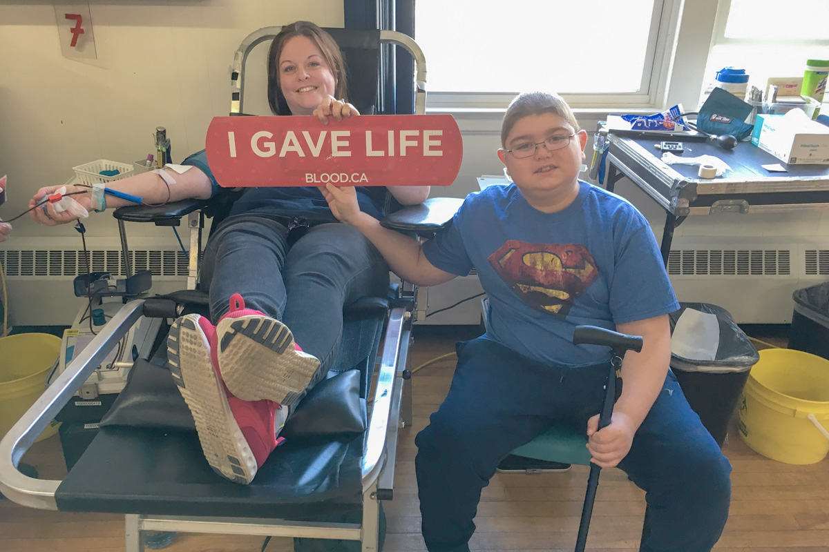 A childhood cancer patient with his mom who is donating blood